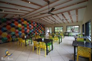 a dining room with tables and chairs in a restaurant at Khushi Riverside Resort & Spa in Mahabaleshwar
