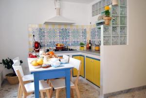 kuchnia z niebieskim stołem, na którym leżą owoce w obiekcie DF bed and breakfast w mieście Manduria