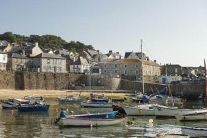 a group of boats are docked in the water at Berlewen, Mousehole in Mousehole