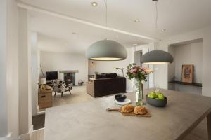 a kitchen and living room with a table with a vase of fruit at Berlewen, Mousehole in Mousehole