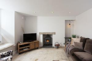 a living room with a couch and a fireplace at Berlewen, Mousehole in Mousehole