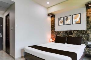 Un dormitorio con una gran cama blanca en una habitación. en Townhouse Oak Gujarat Ganesh Chowkdi Bus Station, en Anand 23 fotos más