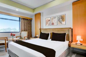 Una habitación de hotel con una cama grande y una ventana. en Townhouse Oak Gujarat Ganesh Chowkdi Bus Station, en Anand
