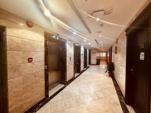 a hallway of a building with doors and tile floors at ضيوف المقام كونكت توصيل للحرم - Diouf Al Maqam Connect Hotel shuttle service to the Haram in Mecca
