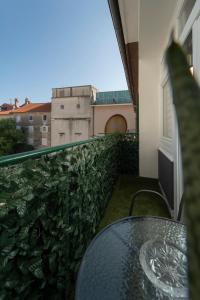 a glass table on a balcony with a view of a building at Piazza dei Signori in Zadar