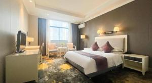 a hotel room with a bed and a television at Kunshan Yuxing Hotel in Kunshan +180 photos
