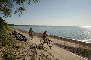 Dos personas en bicicleta en la playa en Brennan Beach Lakeview Loft Park Model 6, en Pulaski