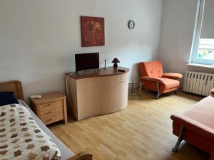 a bedroom with a desk with a tv and a chair at Dähre Wohnung 3 in Niederdorla