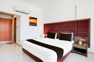 a bedroom with a large bed in a room at Super Townhouse Bharuch Railway Station in Bharuch