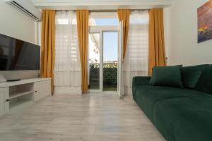 a living room with a green couch and a window at Piazza dei Signori in Zadar