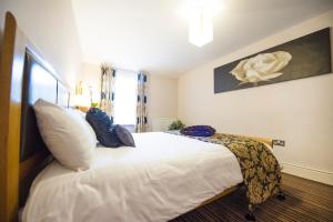 a bedroom with a large bed with white sheets at Chester Apartments in Chester