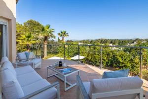 un patio con sofás y una mesa en el balcón en Villa Verde, en Pollensa