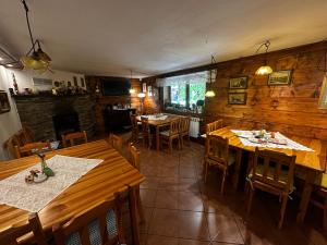 a restaurant with wooden tables and chairs and a fireplace at Villa Fiore in Biały Dunajec