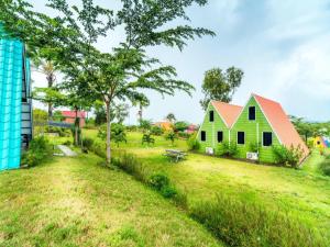 a green house with a red roof in a field at Dreamland Beach Holiday in Kudat