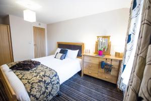 a small bedroom with a bed and a dresser at Chester Apartments in Chester