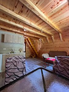 a kitchen and a living room with wooden ceilings at Guesthouse Stanisic in Dobrilovina