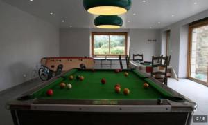 a living room with a pool table with balls on it at Gîte de charme avec piscine au cœur de la nature in Hénon