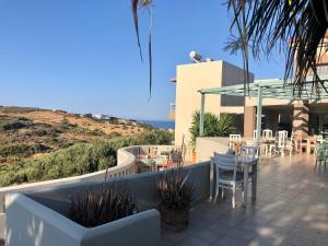 a patio with tables and chairs on a house at Pelagia Bay Hotel in Agia Pelagia
