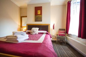 a bedroom with a pink bed with towels on it at Chester Apartments in Chester