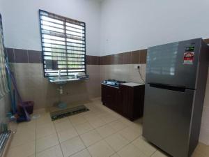 a kitchen with a refrigerator and a window at OYO Homes 90606 Casaria Cherating in Cherating +12 photos