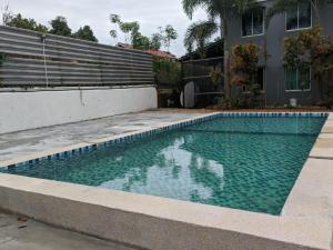 a swimming pool in front of a house at Bull & Bear Airport Hotel Langkawi in Kampung Padang Masirat