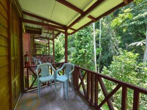 a porch of a house with two chairs on it at OYO 90630 Mat Leon Village in Kuala Tahan