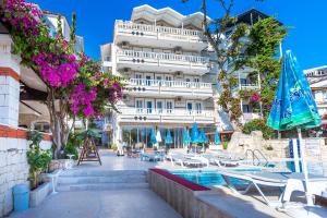 un hotel con piscina frente a un edificio en Habesos Hotel, en Kas