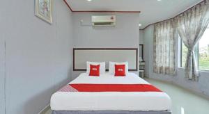 a bedroom with a large bed with red pillows at SUPER OYO 818 Hotel 11 in Bandar  Pusat Jengka +27 photos