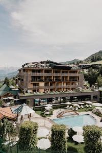 a hotel with a swimming pool and a resort at Hotel Berghof - St Johann in Salzburg in Sankt Johann im Pongau