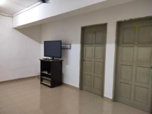 a room with two doors and a tv on a stand at Travellers Space 2 in Kuantan