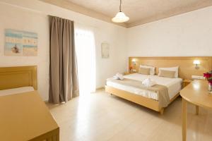 a bedroom with a bed and a table in it at Pelagia Bay Hotel in Agia Pelagia