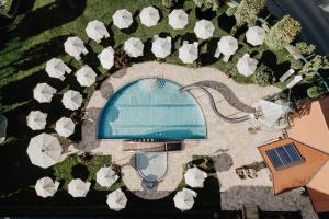 an overhead view of a pool with white umbrellas at Hotel Berghof - St Johann in Salzburg in Sankt Johann im Pongau