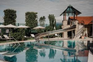 a swimming pool with a slide in a resort at Hotel Berghof - St Johann in Salzburg in Sankt Johann im Pongau