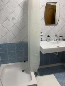 une salle de bains avec lavabo et baignoire dans l'établissement Beige Apartments, à Struga