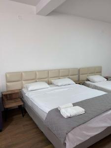 une chambre avec deux lits avec des draps blancs dans l'établissement Beige Apartments, à Struga