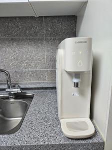 un presse-agrumes assis sur un comptoir à côté d'un évier dans l'établissement You Here,Stay - 5min to Hapjeong Station, 10mins to Hongdae, à Séoul