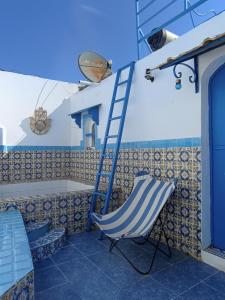 a blue ladder and a chair on a patio at Dar Warda in Bizerte