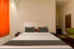 a bedroom with a large white bed with two pillows at RROOMS Hotel Riddhi Inn in Lucknow