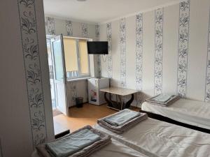 a room with two beds and a table in it at Jany Tilek in Bosteri +24 photos