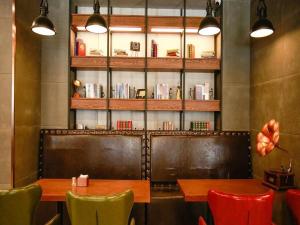 a restaurant with two tables and chairs and a book shelf at James Joyce Coffetel Harbin Railway Station Songlei Yuanda Pedestrian Street in Harbin