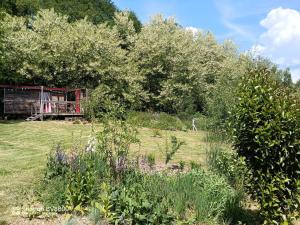 a garden with trees and flowers in front of a building at La Haute Brunie in Roussines