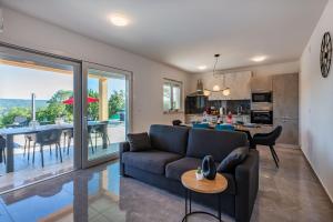 a living room and kitchen with a couch and a table at Villa Mia in Labin, a two apartment villa with pool close to the sea in Krapan
