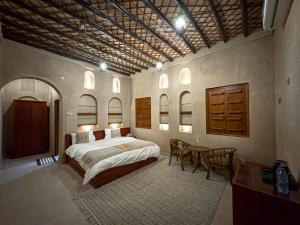 a bedroom with a bed and a table and chairs at IHYAA Inn - نزل إحياء in Nizwa