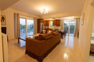 a living room with a couch and a dining room at Izzy's apartment in Nafpaktos