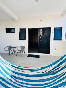 a hammock in a room with a table and chairs at La Ventana Apartments Biznaga 2 in La Ventana