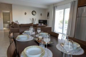 a dining room with a table with plates and wine glasses at Izzy's apartment in Nafpaktos +24 photos