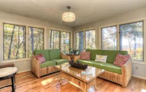 a living room with chairs and a table and windows at Vista Haven - Mountain Views and Fireplace and Big Screen TVs and Extras in Jasper