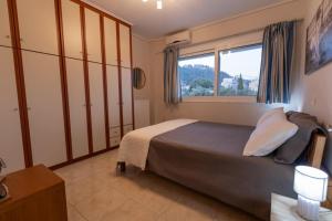 a bedroom with a large bed and a window at Izzy's apartment in Nafpaktos