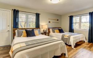 two beds in a bedroom with blue curtains at Vista Haven - Mountain Views and Fireplace and Big Screen TVs and Extras in Jasper