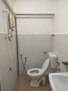 a white bathroom with a toilet and a sink at Travellers Space 2 in Kuantan